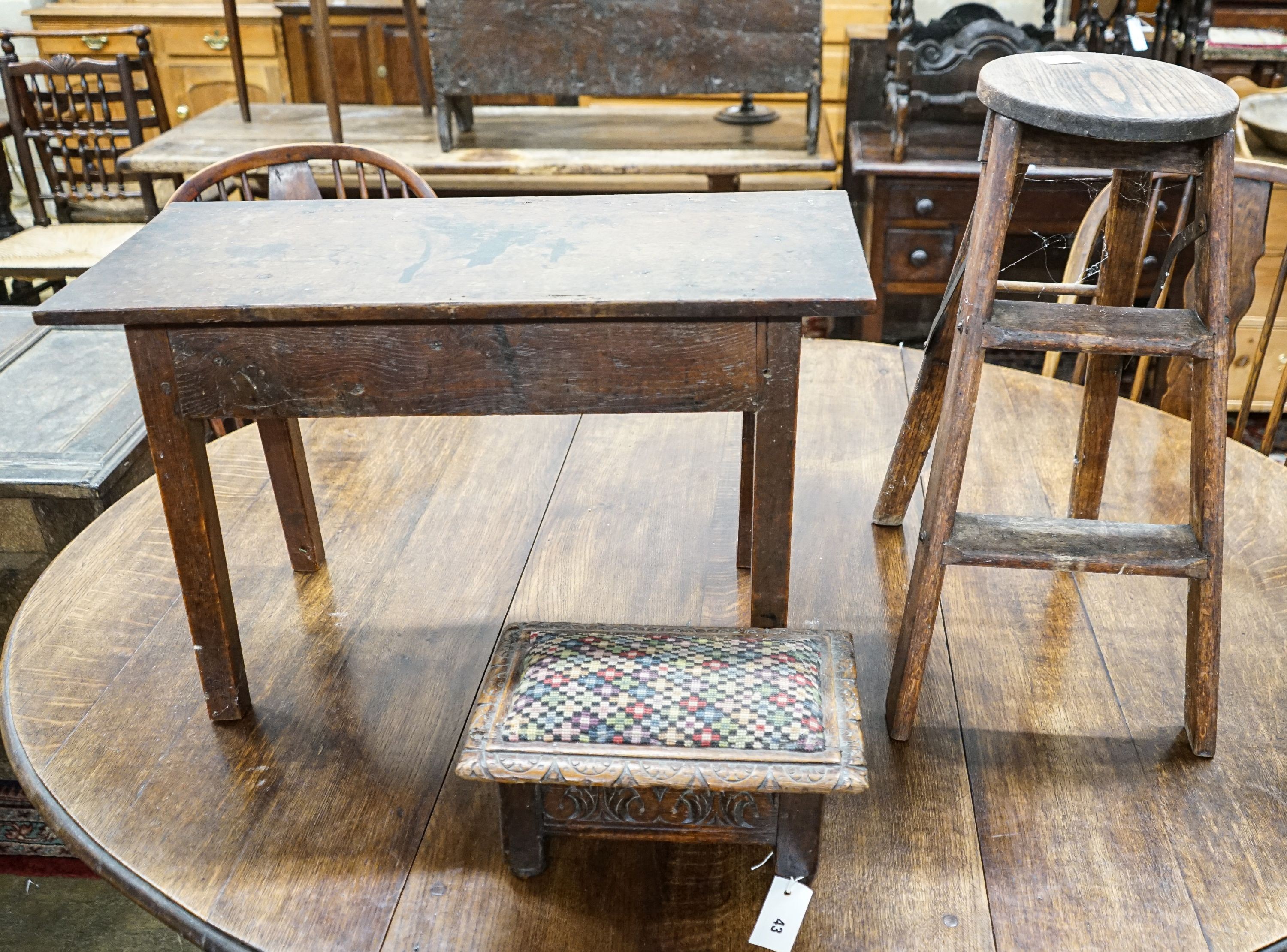 An 18th century oak low table, width 74cm, height 32cm, a carved oak foot stool and an Edwardian oak folding steps stool